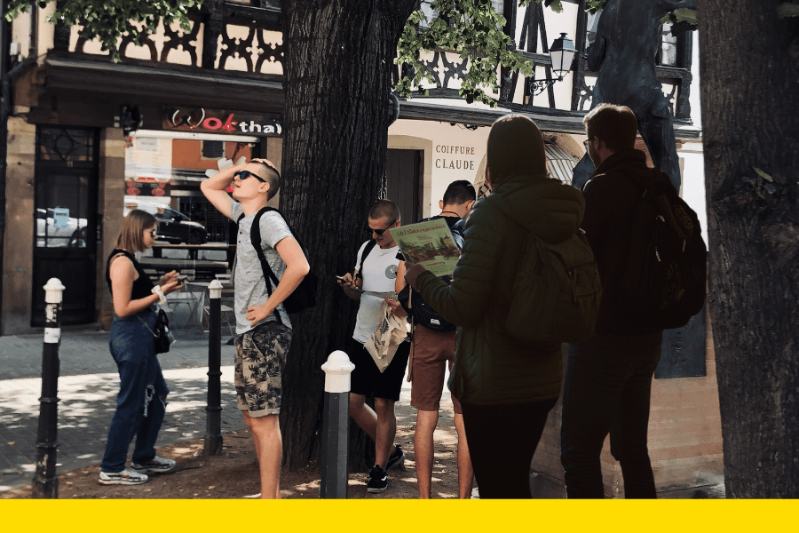 Un groupe de participants en pleine réflexion lors d’un escape game extérieur à Strasbourg, explorant les rues et résolvant des énigmes captivantes.