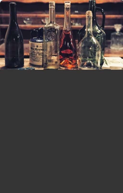Des bouteilles d'alcool sur un bar en bois