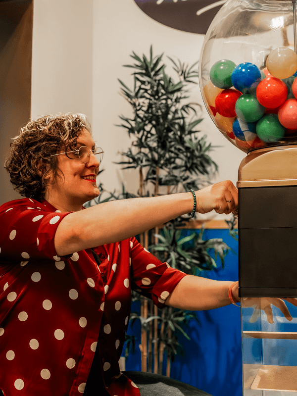 Nos Aventures 4 Participante utilisant une machine à boules colorées dans la salle Las Vegas : Nuit de folie, aventure immersive de 60 minutes chez Les Secrets du Sablier à Strasbourg.